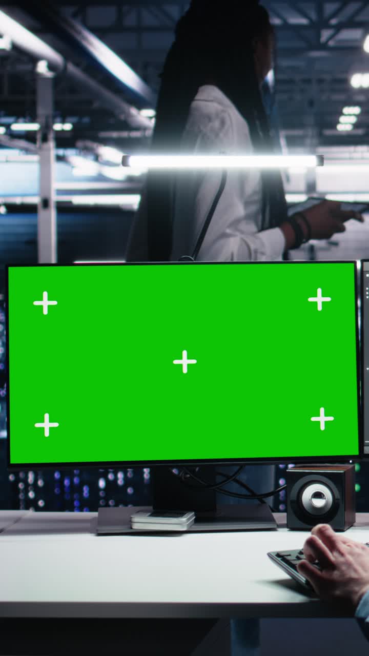 Vertical video Server room technician using AI on green screen PC