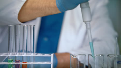 scientist hands pouring liquid samples into test tubes. laboratory equipment