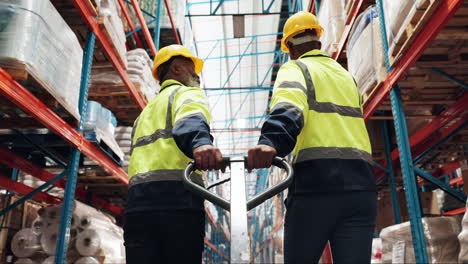 two warehouse workers pushing a pallet jack through a warehouse aisle