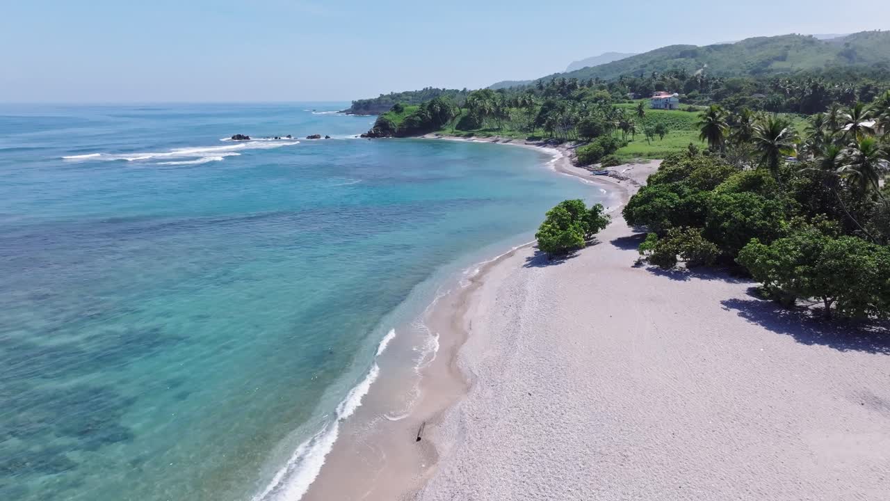 Riprese aeree in avanti sulla costa di un'isola tropicale con una bellissima spiaggia di sabbia