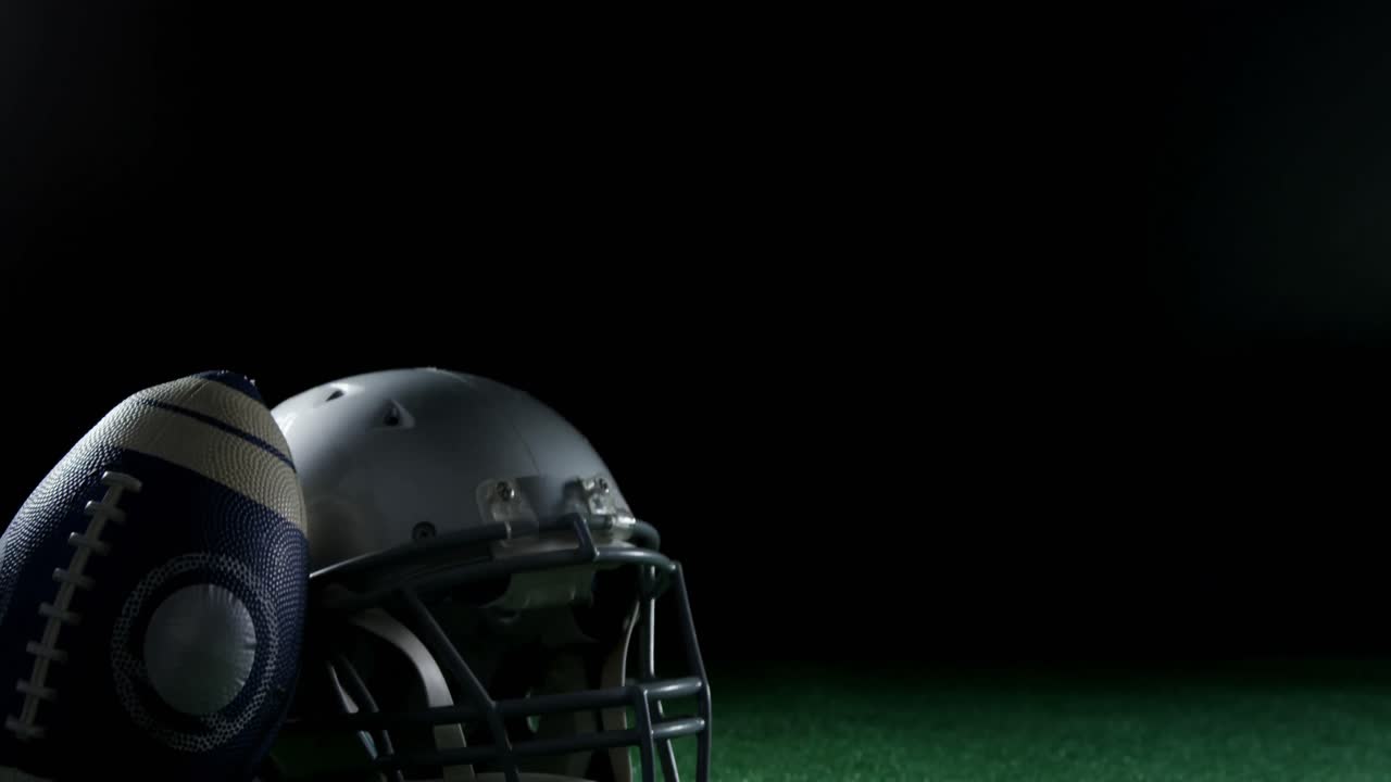 Pallone da football americano appoggiato sul casco 4k