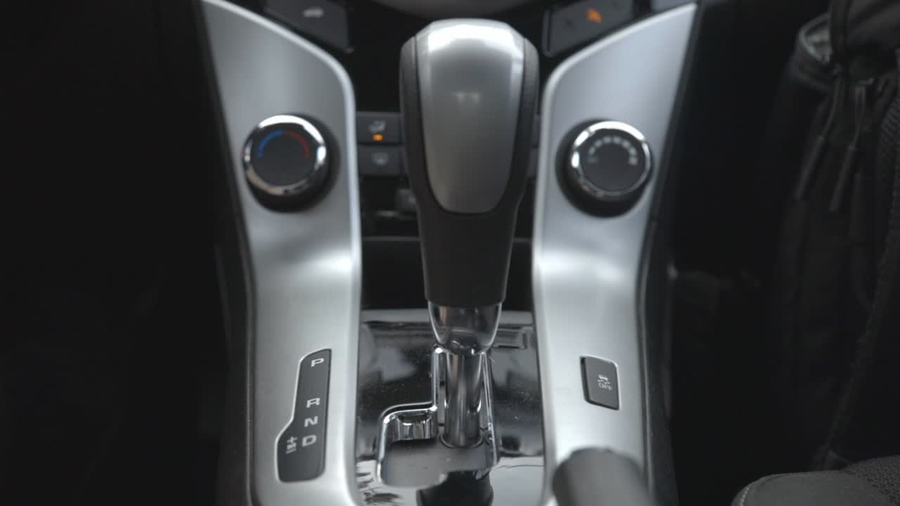 Driver's Hand Shifting The Car's Center Console To Drive - close up slowmo