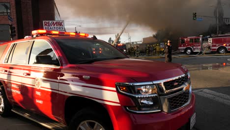 Gebäude-In-Brand-Mit-Feuerwehrautos-Im-Blick