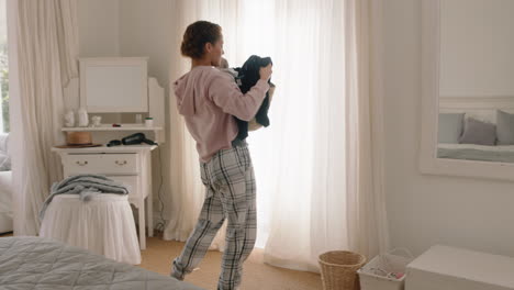 Una-Adolescente-Feliz-Bailando-En-El-Dormitorio-Limpiando-La-Ropa-Divirtiéndose-Bailando-Sintiéndose-Positiva-Celebrando-El-Fin-De-Semana-Usando-Pijamas-En-Casa