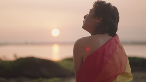 person at sunset with pride flag