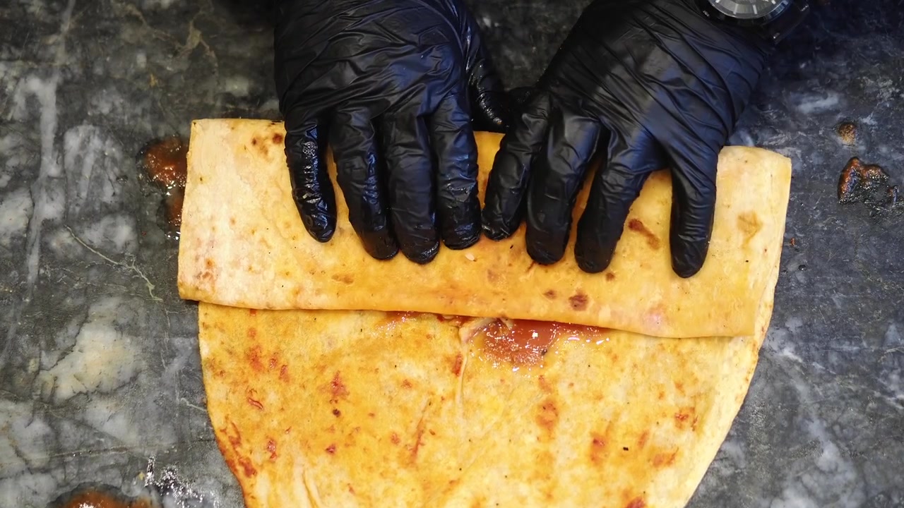 Chef Rolling a Delicious Chicken Shawarma Wrap with Fries and Sauce