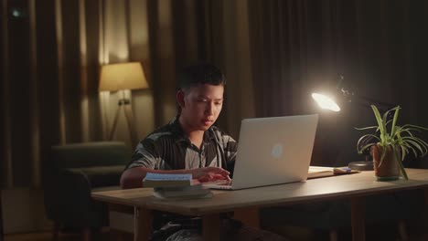 asia boy use laptop computer at home, teenage boy learning online from laptop at night