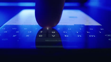 밤에 화면에 sms를 입력하는 젊은 남자의 손의 클로즈업 파란색 배경