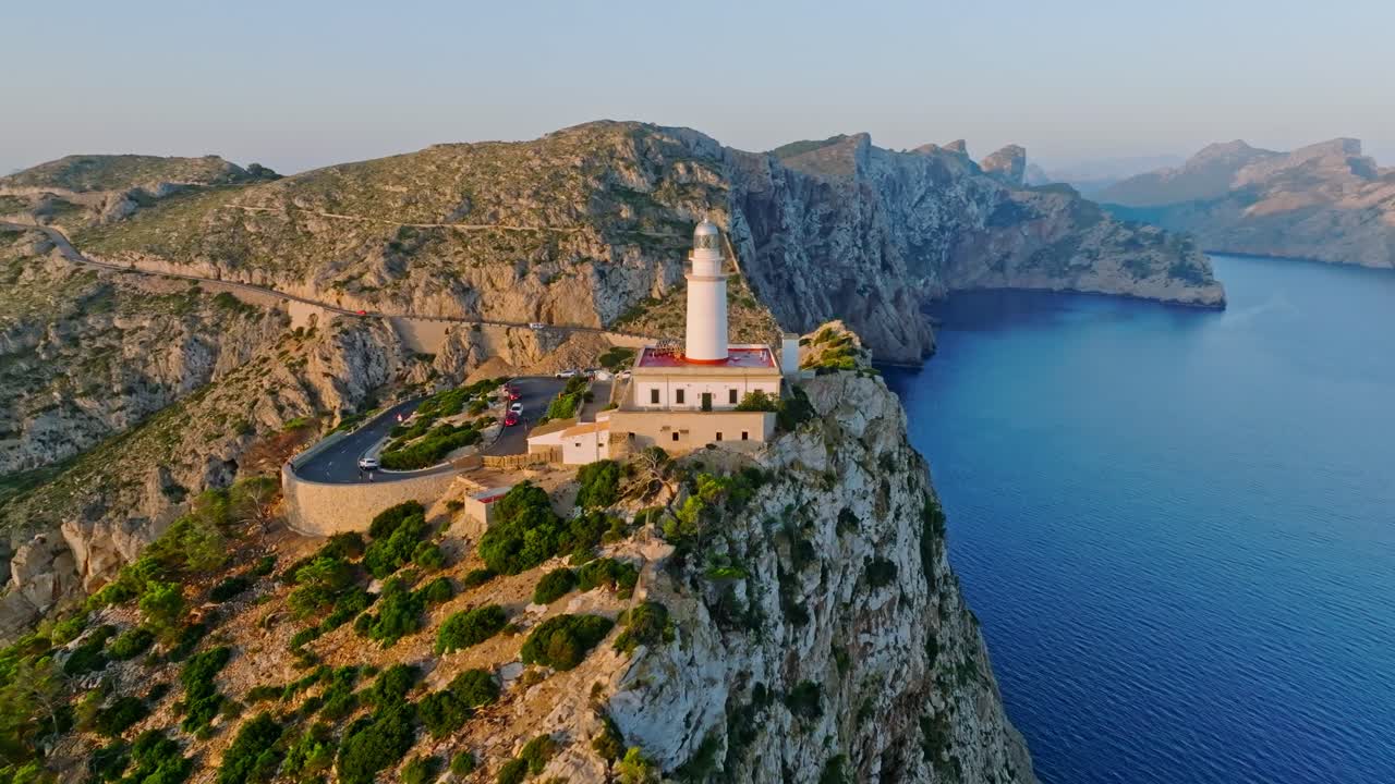Vibrant golden light spread across rocky cliff and road at Formentor lighthouse, Serra de Tramuntana Mallorca Spain
