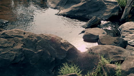 water moving through the rocks in a river and being touched by the wind