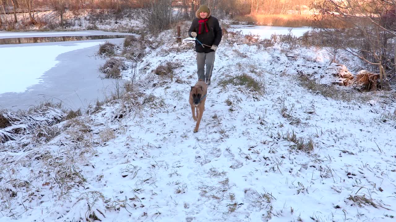 hombre caminando con el perro en invierno