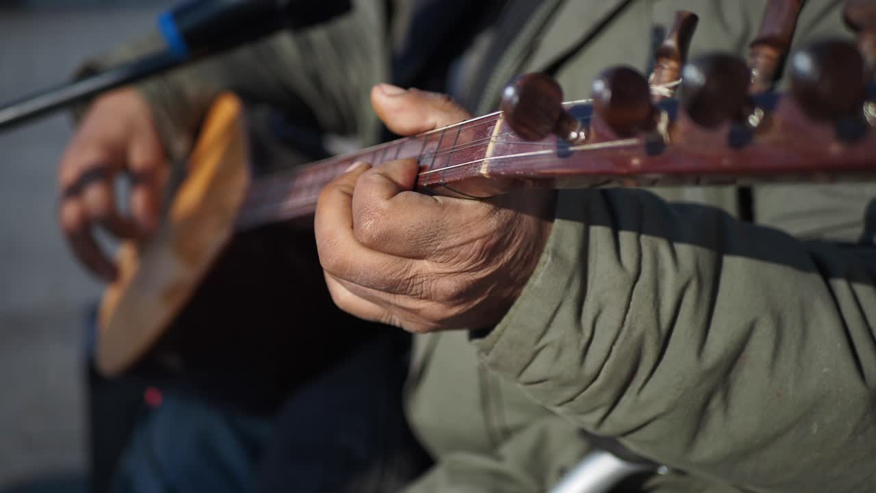 un hombre tocando un instrumento de cuerda