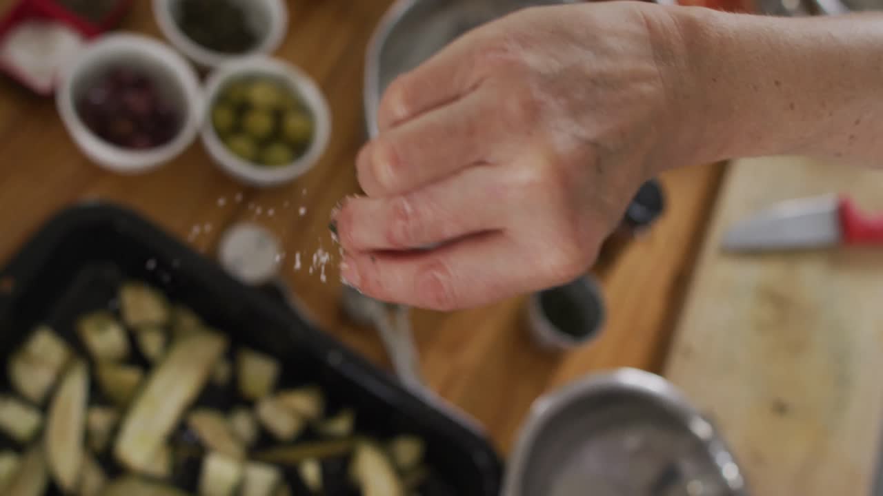 cocinera caucásica que enseña a un grupo diverso usando máscaras faciales