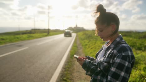 woman using phone by the roadside