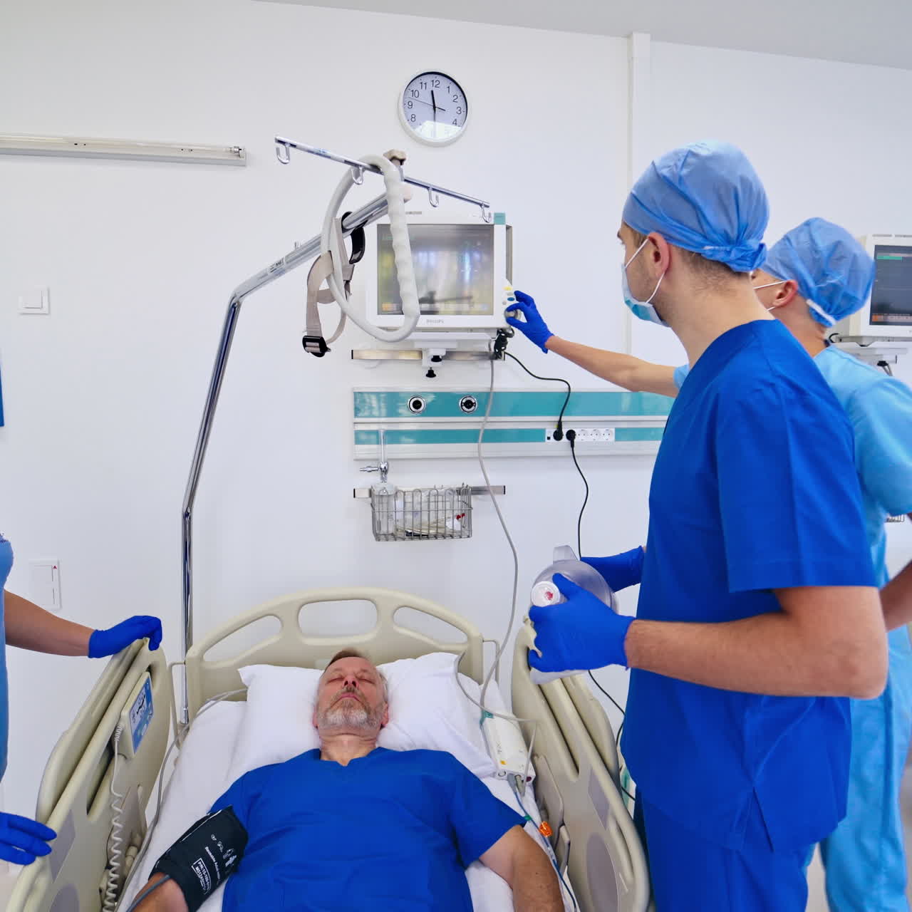 Light emergency room background with patient in bed and doctors. Medical specialists and a nurse in blue uniform helping patient in modern clinic.