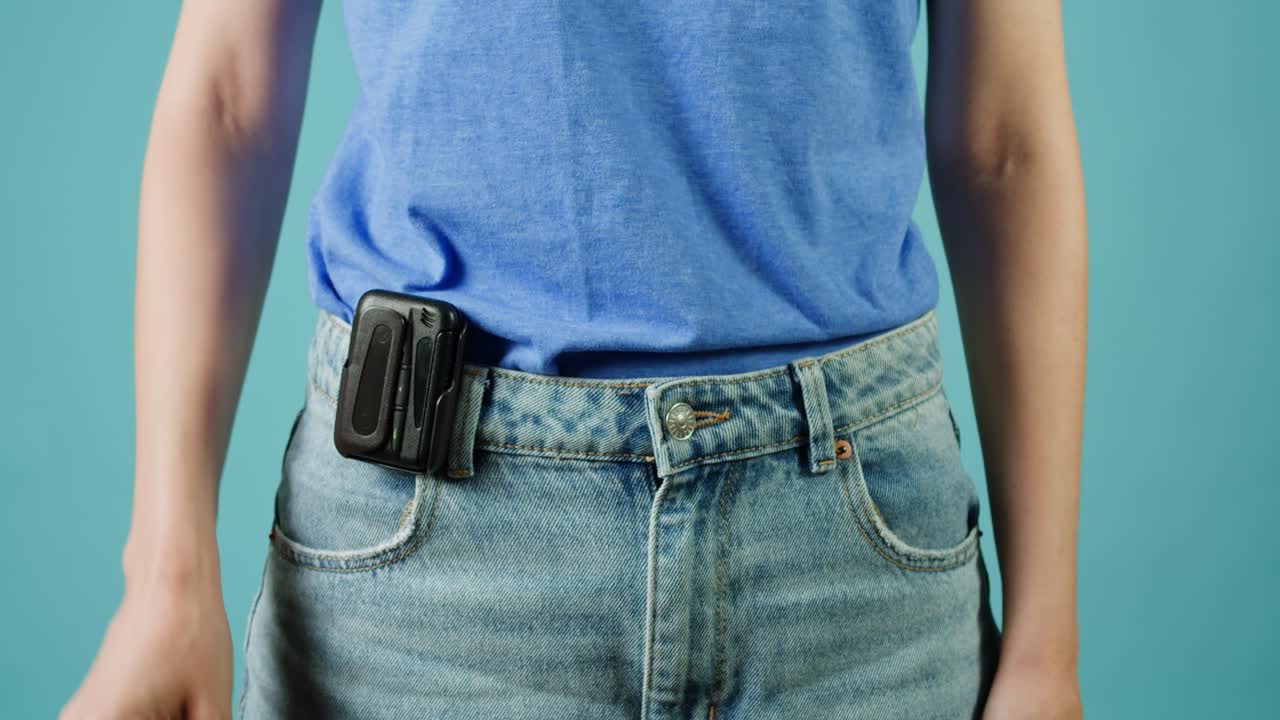 여자 가 주머니 에 기기 를 넣고 있다