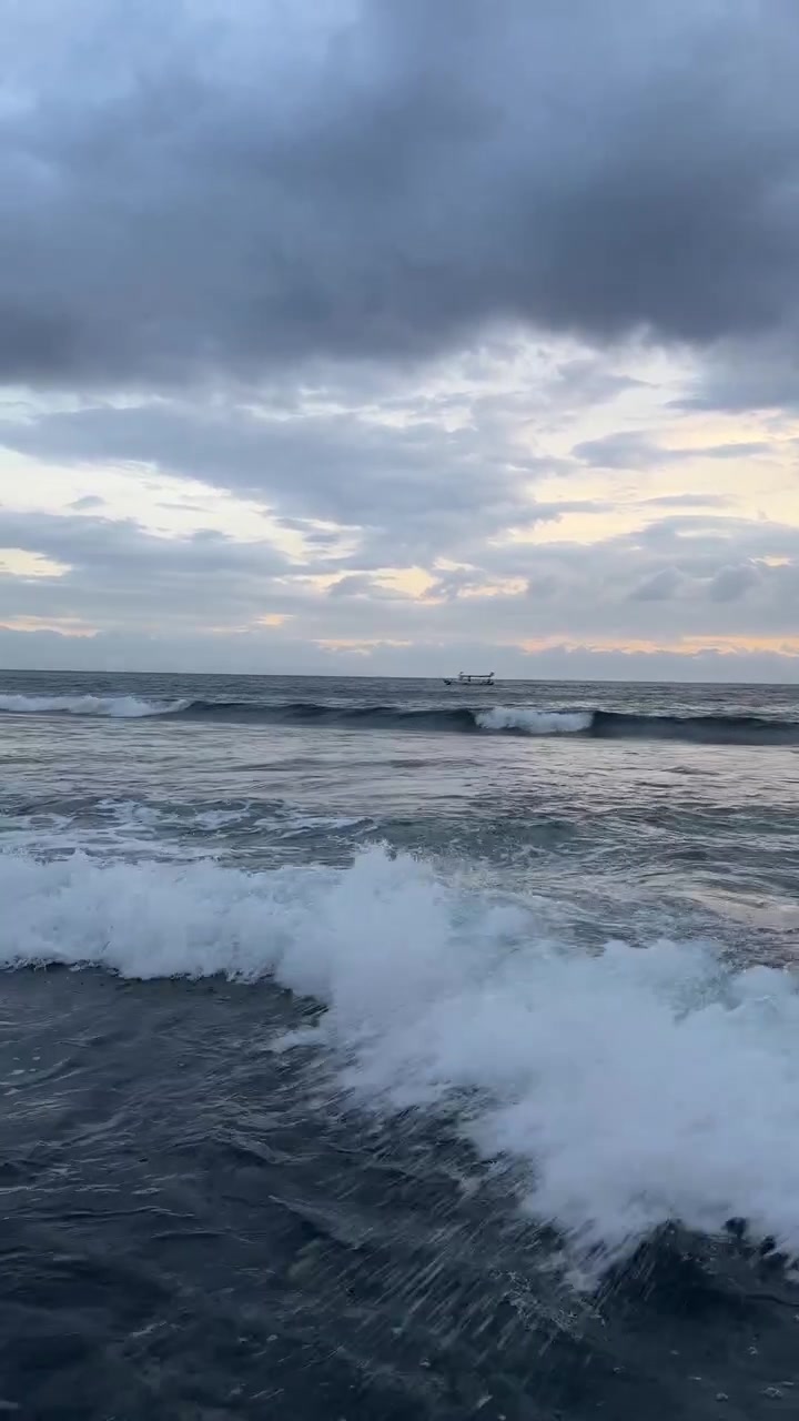 Ocean Waves Crashing on a Cloudy Morning with a Distant Boat