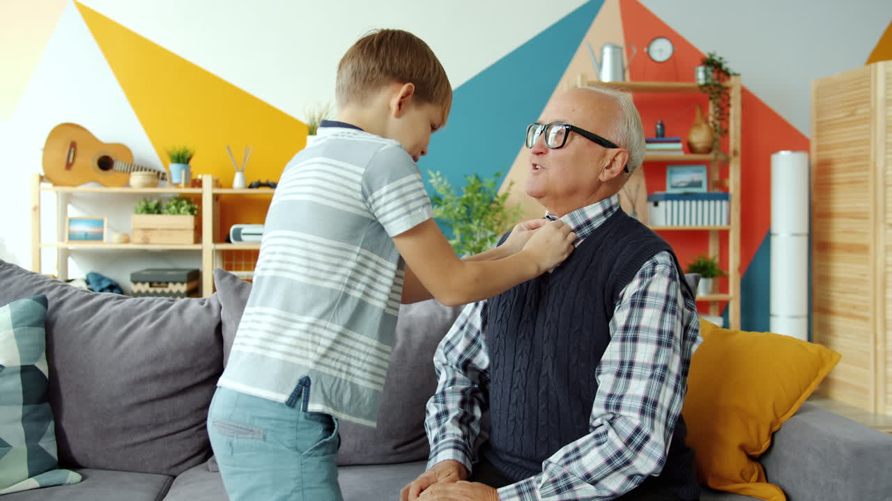 Grandson helps grandfather dress
