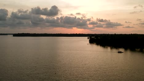 Wunderschöne-Luftaufnahme-Eines-Backwater-Vembanadu-Sees,-Wasserleitungen,-Sonnenuntergang-In-Der-Dämmerung,-Kokosnussbäume,-Wassertransport,-Wolken,-Reflation,-Hausboot,-Wasserleitungen