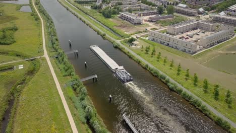 Luftdrohnenansicht-Der-Epischen-Szene-Großes-Schiffsschiff-Oder-Boot,-Das-Am-Kanal-In-Den-Niederlanden-Vorbeifährt