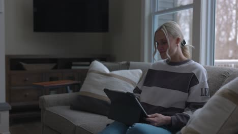 Frau,-Die-Zur-Couch-Geht,-Um-Sich-Hinzulegen-Und-Durch-Das-Tablet-Zu-Scrollen,-Während-Sie-In-Einem-Schönen-Haus-Kaffee-Trinkt