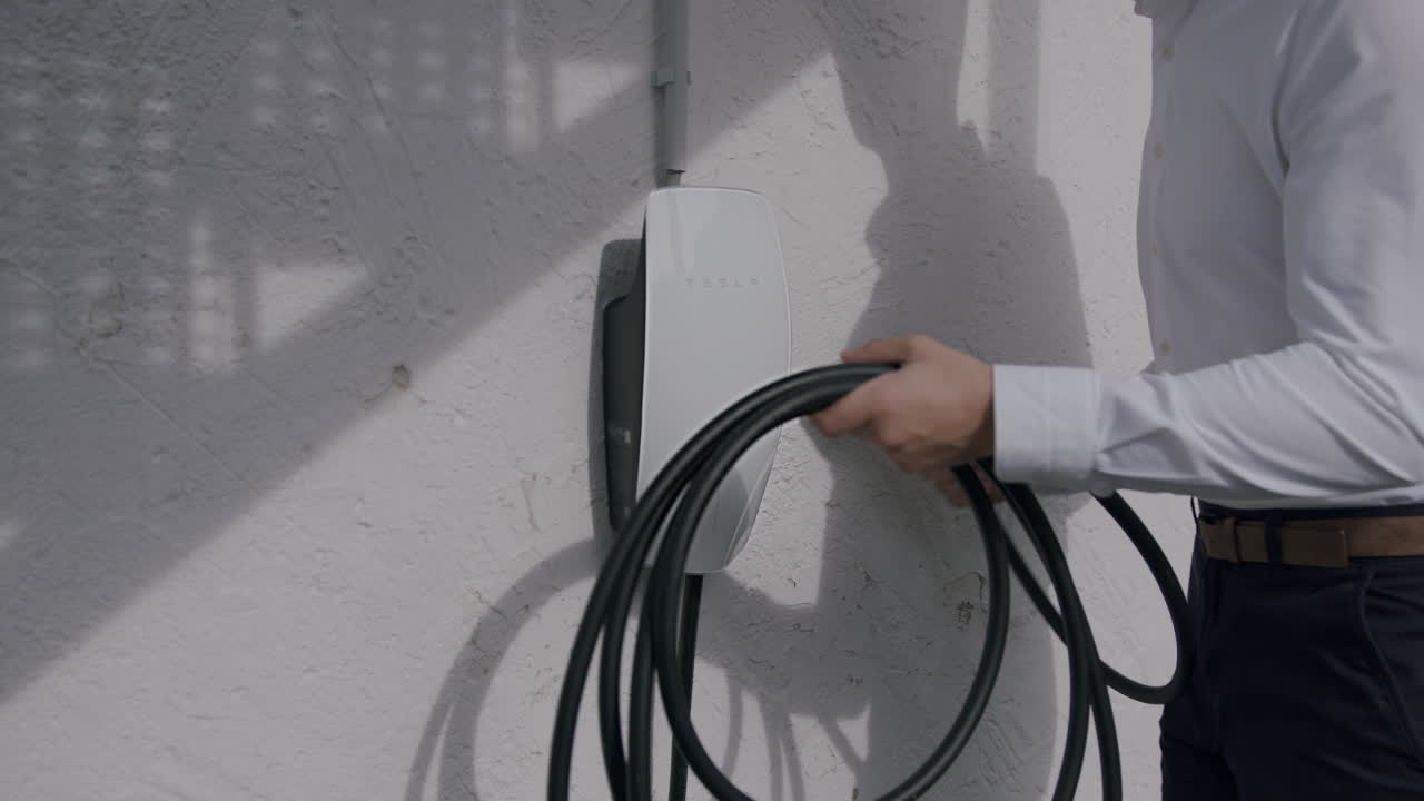 alguien toma el enchufe de la estación de carga del hogar