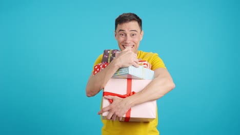 man holding a stack of gifts on a blue background