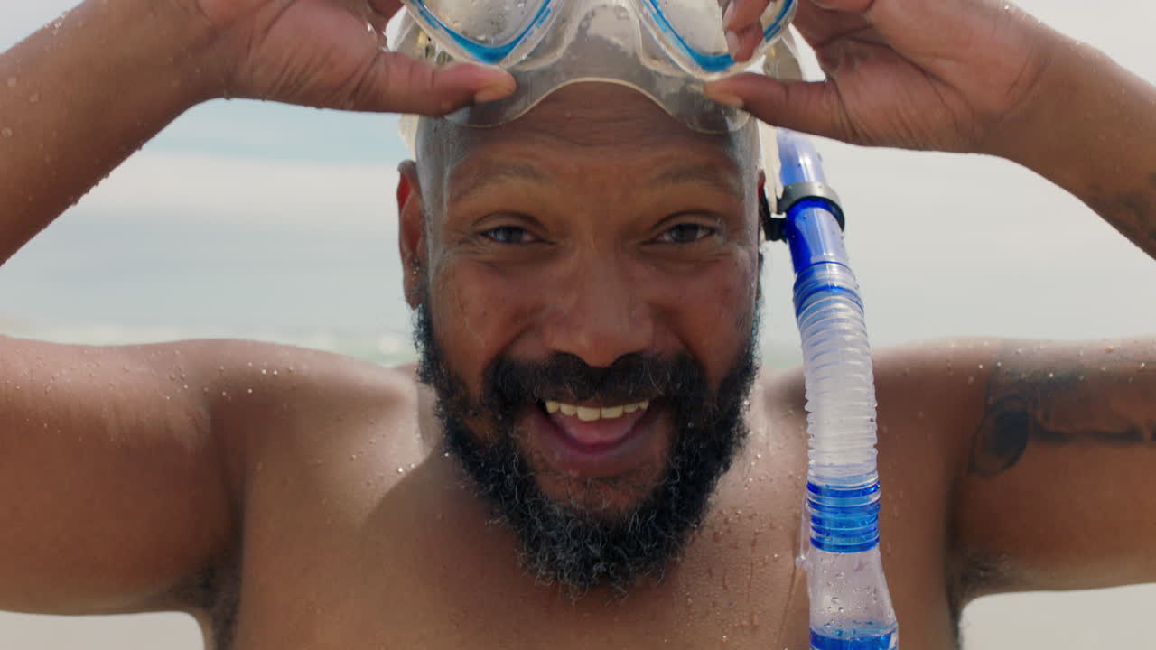 retrato feliz hombre afroamericano con gafas y snorkel sonriendo disfrutando de un día soleado en la playa listo para nadar en el mar 4k
