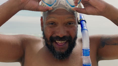 Porträt-Eines-Glücklichen-Afroamerikanischen-Mannes-Mit-Schutzbrille-Und-Schnorchel,-Der-Lächelnd-Einen-Sonnigen-Tag-Am-Strand-Genießt-Und-Bereit-Ist,-Im-Meer-Zu-Schwimmen-4k