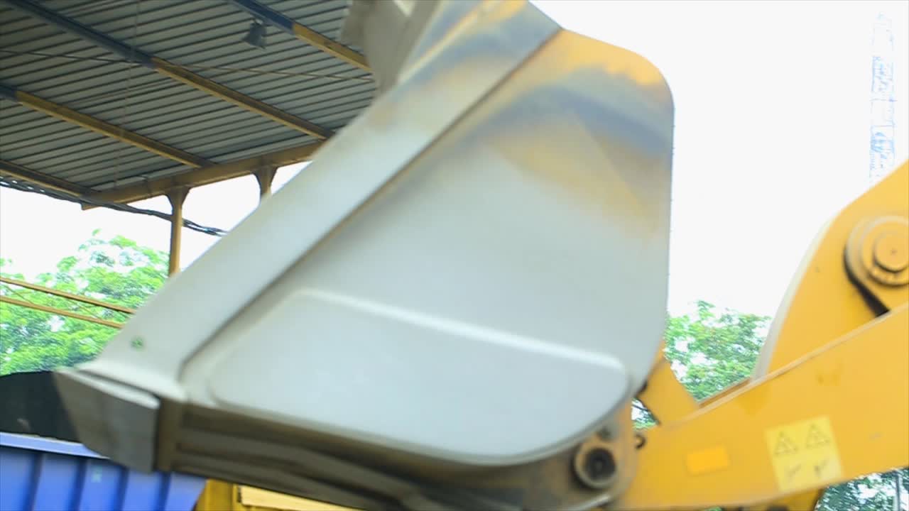 el cargador de ruedas transporta materiales al contenedor frío de la fábrica de la planta de mezcla de asfalto