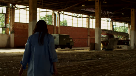 woman walking through an abandoned factory