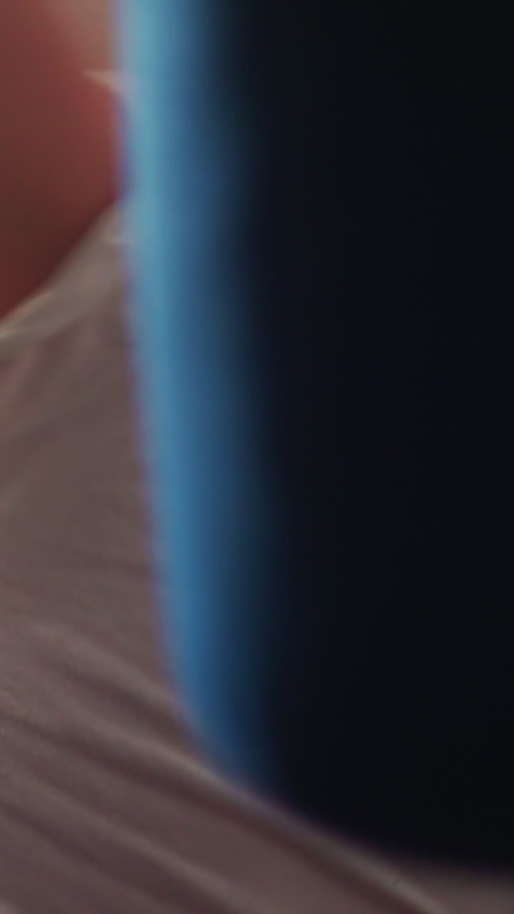 Motivated little boy punches hanging bag with boxer gloves. Active kid takes professional boxing classes to develop new skills in gym closeup slow motion