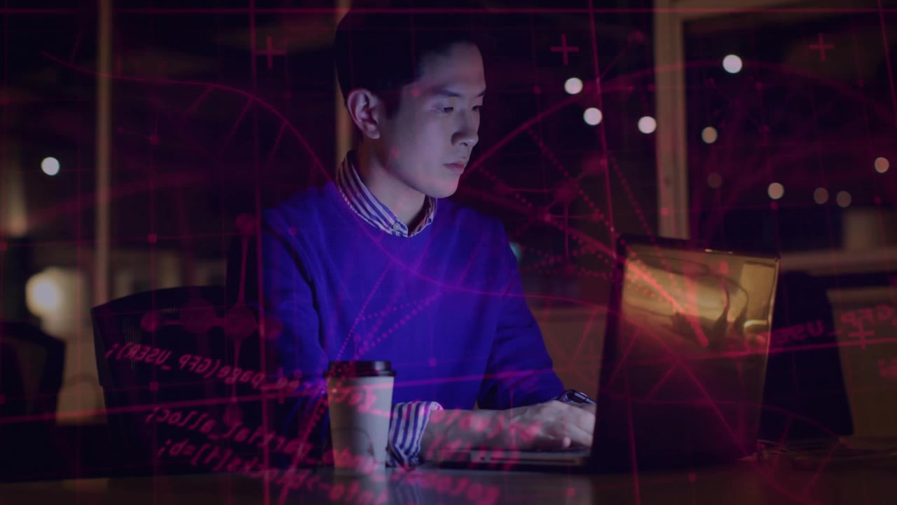 IT professional typing code in modern office at night, with red code overlay and network graphics