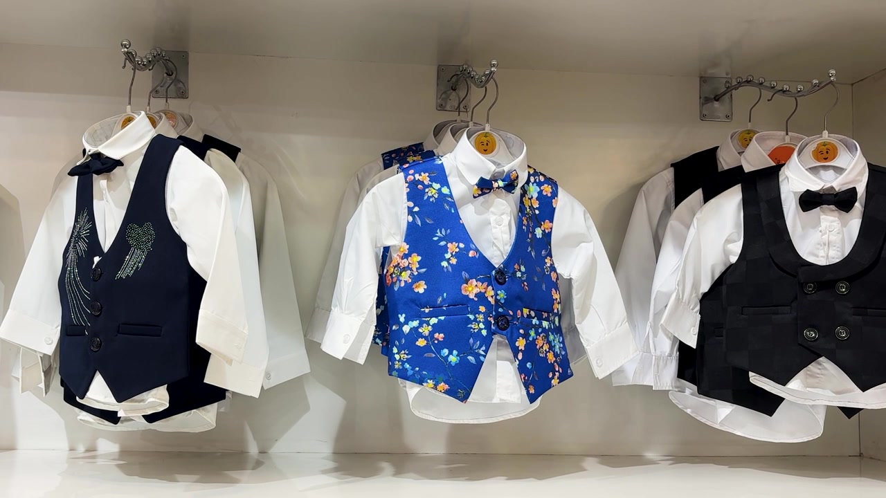 子供服店に陳列された、スタイリッシュな男の子用フォーマルベストスーツ。