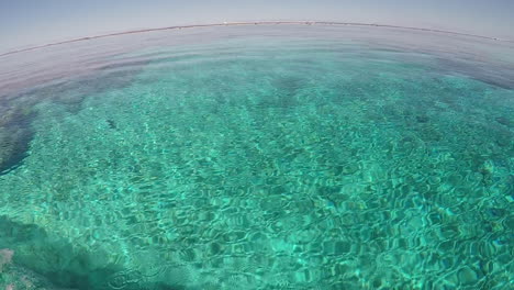 Navegando-Alrededor-De-Un-Arrecife-De-Coral,-Vista-En-Barco-Con-Estela-De-Aguas-Bravas-En-La-Mano