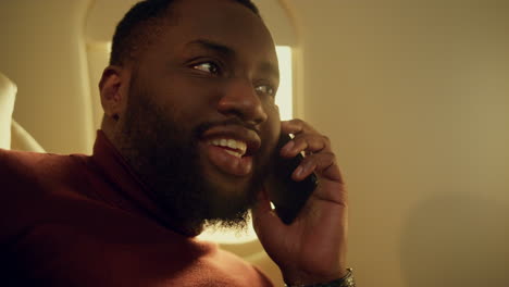 happy man picking call at airplane window closeup. smiling businessman speaking