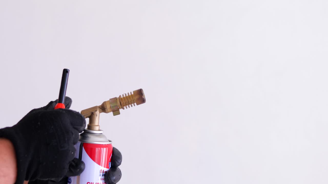 라이터가 있는 깨끗한 공간에 사람이 휴대용 부탄 토치를 들고 있습니다.