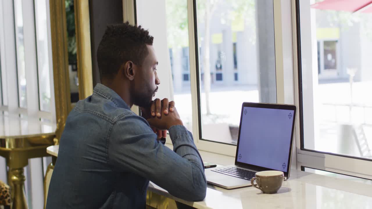 African american businessman using laptop in cafe