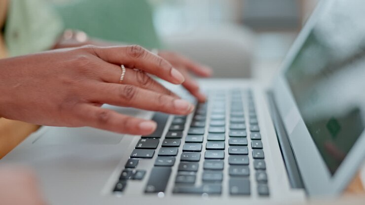 Mani, portatile e una donna che digita per il suo design