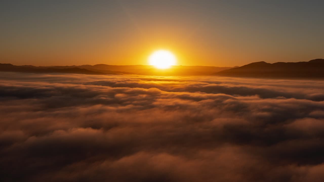 Beautiful time lapse capturing sunrise colors over soft, fluffy clouds in the sky