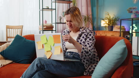 tired exhausted woman freelancer working on laptop with many sticker task inscriptions deadline