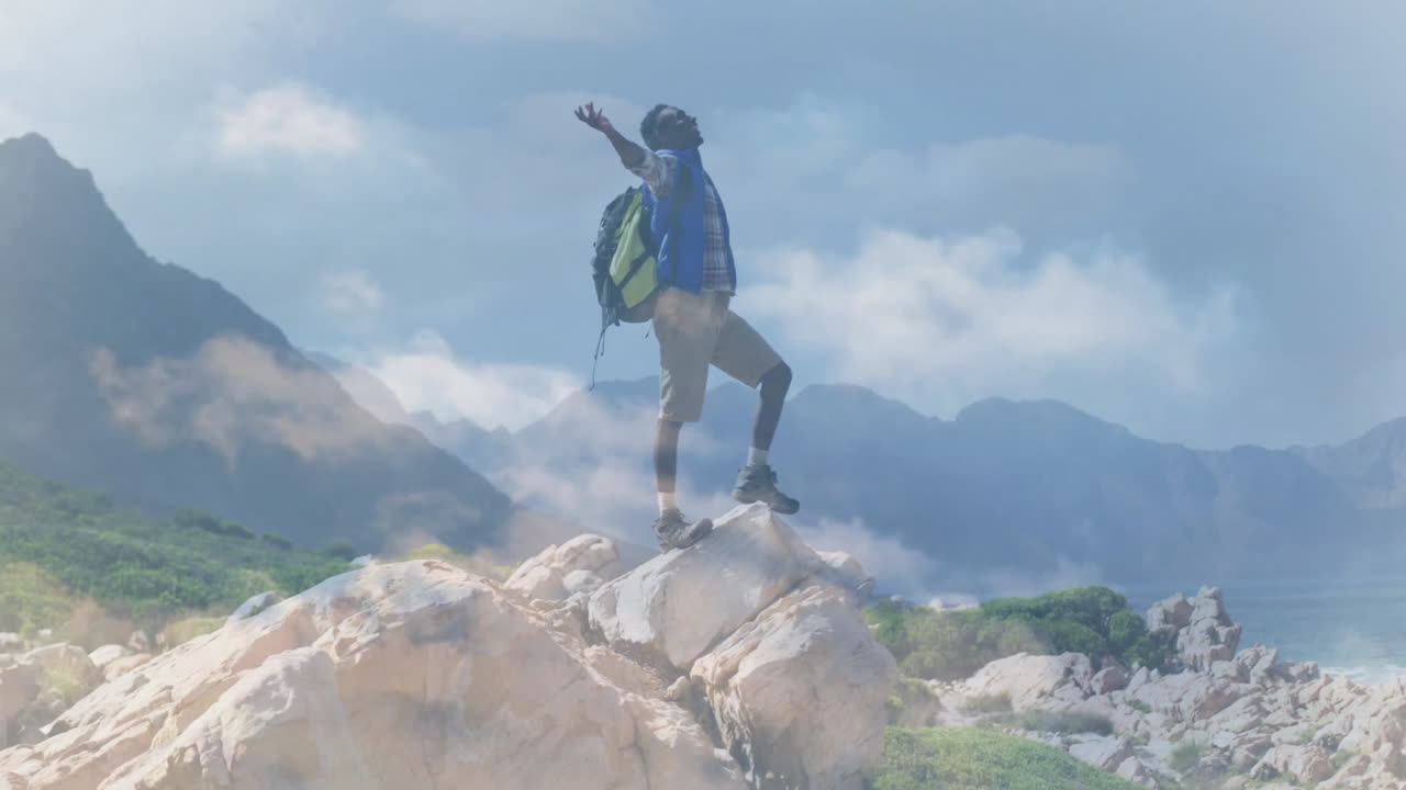 Man raising arms on coastal peak for travel campaign, showing animated compass and elevation chart