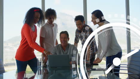 clock animation over diverse business team collaborating around laptop in office