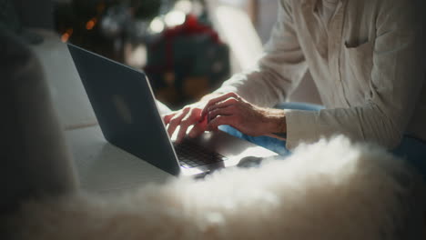 close-up of hands of man who writes on laptop answers email to client works remotely from home