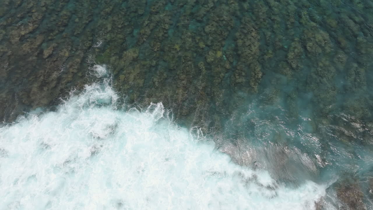 Drone top down overhead view of whitewash from waves crashing on fringing reef