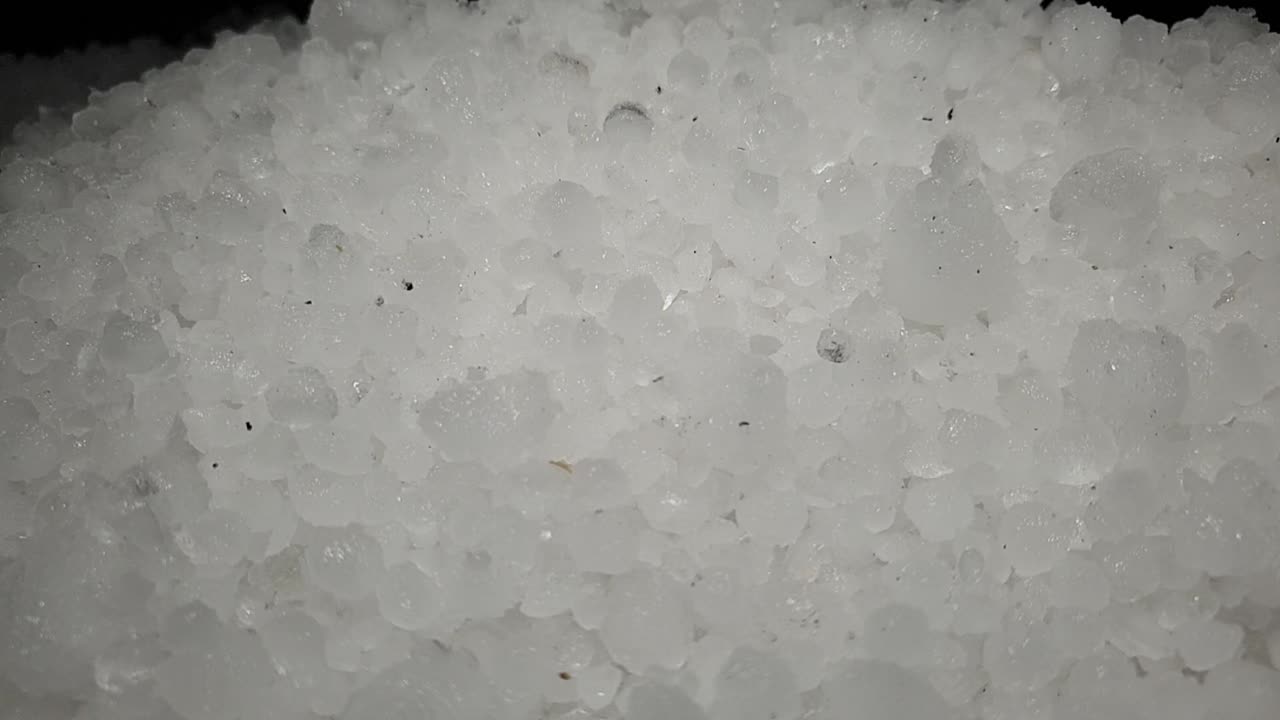 bolas de hielo de tormenta de granizo blanco que se palean y se mueven en una pila para su limpieza y eliminación