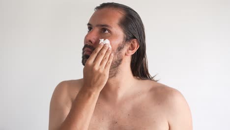 hombre haciendo cuidado de la piel para cuidar de su cara, hombre latino, hombre barbudo, cara y nariz limpieza e hidratación, tonificación