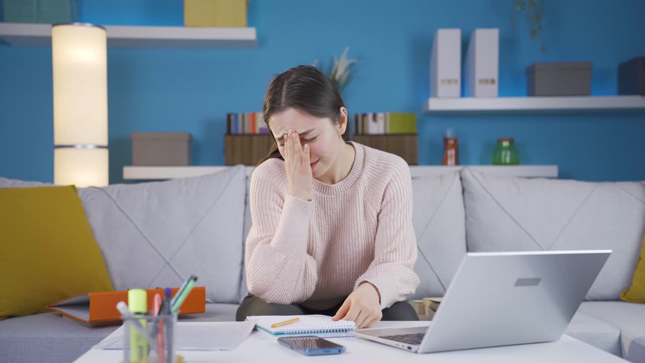 아시아의 젊은 여성이 집 사무실에서 기억하고, 잊음으로 고통받고 있습니다.