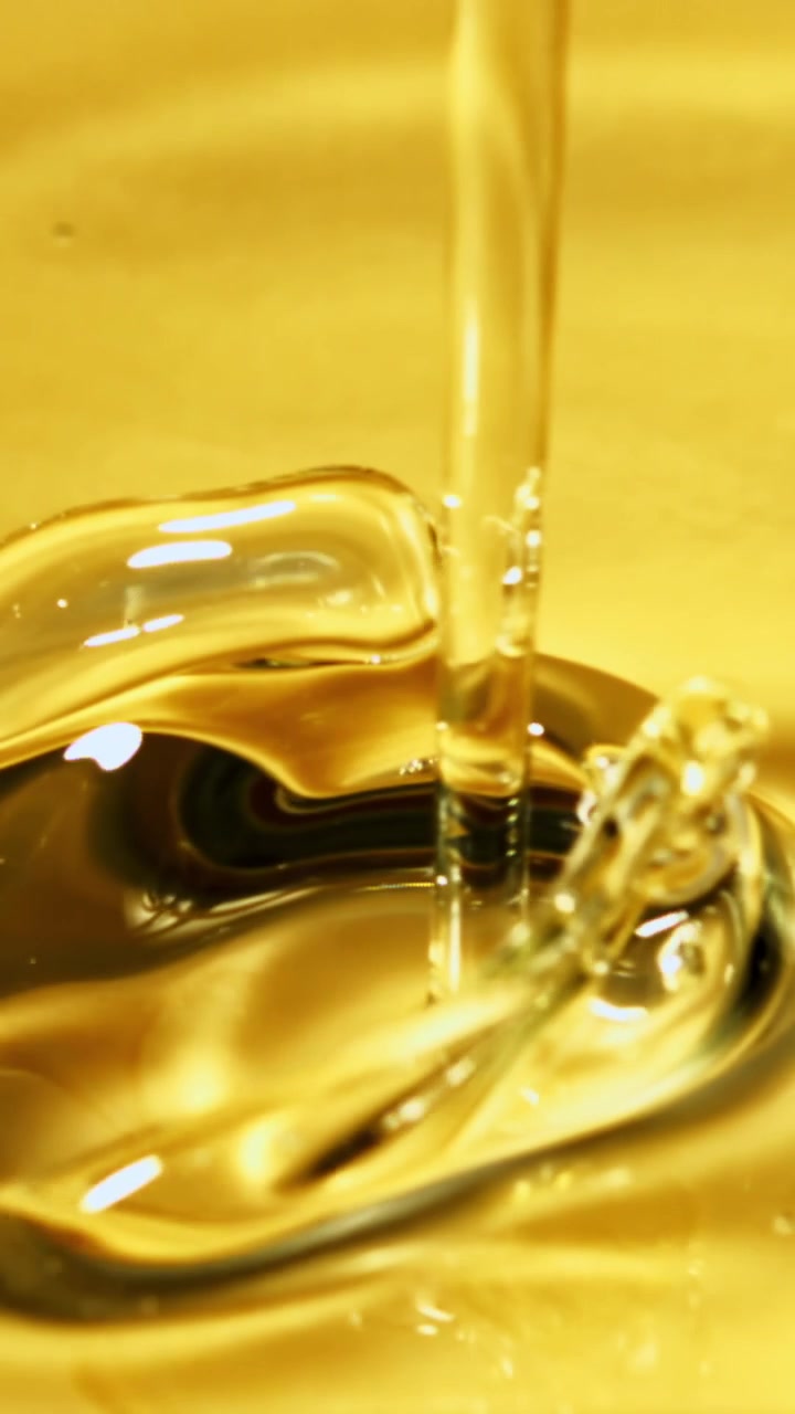 Close-up of Golden Viscous Liquid Pouring and Rippling
