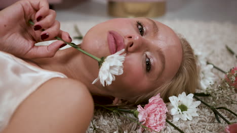 girl touching her face with daisy